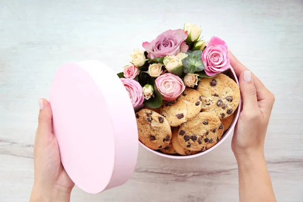 Fiorista preparare scatola con fiori e biscotti — Foto Stock