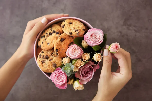 Floristería preparando caja con flores y galletas — Foto de Stock