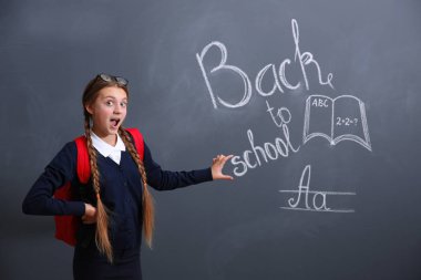 Blackboard yakınındaki sırt çantası ile kız