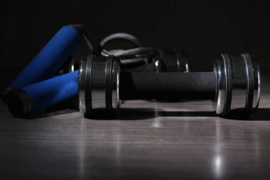Dumbbell ve ahşap yüzey üzerinde atlama ipi