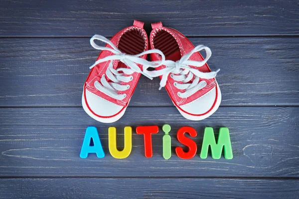 Word AUTISM with kids shoes