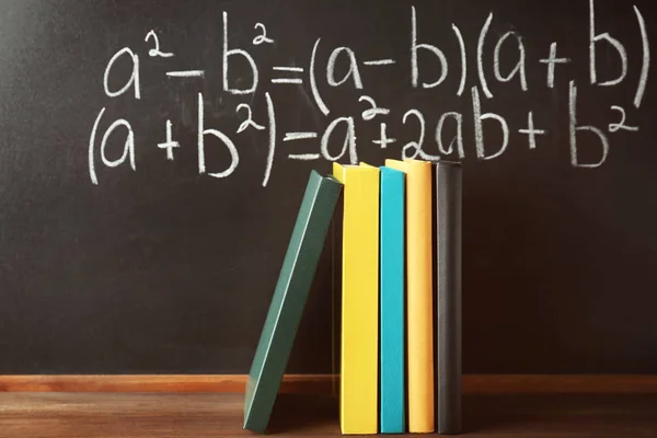 Books on blackboard background — Stock Photo, Image