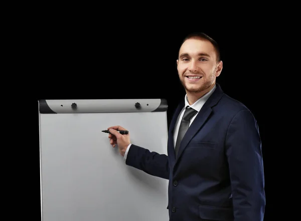 Young businessman standing near flip chart — Stock Photo, Image