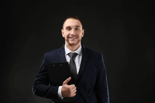 Giovane business coach con appunti in piedi su sfondo nero — Foto Stock