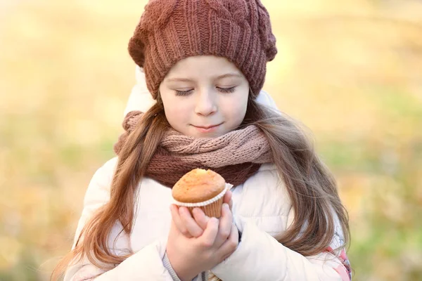 Маленькая девочка ест вкусный кекс — стоковое фото