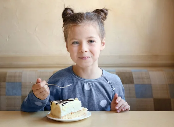 Little girl eating tasty cake — Stock Photo, Image
