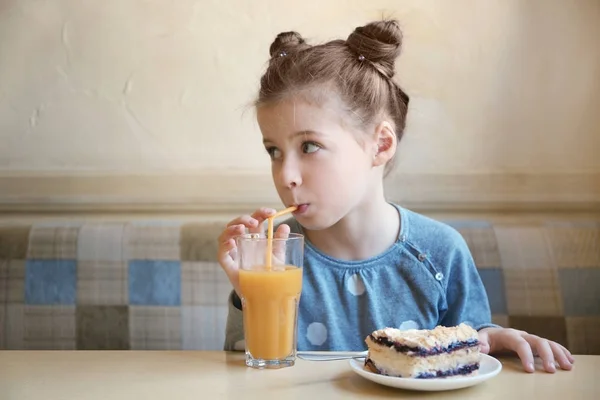 Милая маленькая девочка с тортом и соком — стоковое фото