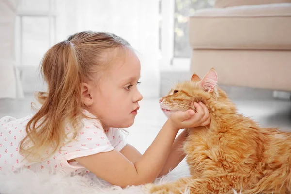 Милая маленькая девочка с красной кошкой — стоковое фото