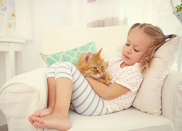Kırmızı kedi ile sevimli küçük kız — Stok fotoğraf