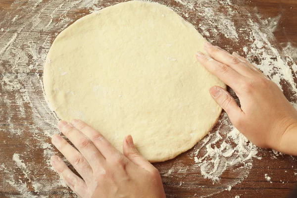 Vrouwelijke handen en uitgerold deeg — Stockfoto