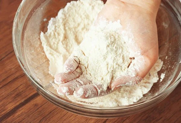 Female hand and glass bowl with flour — Stock Photo, Image