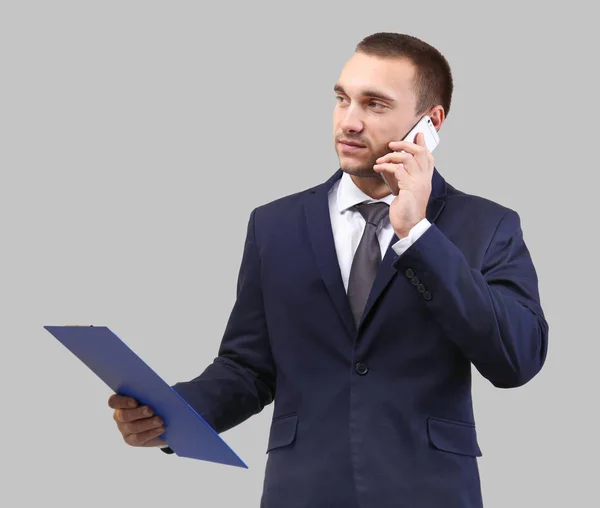 Hombre Guapo Sujetando Portapapeles Mientras Habla Por Teléfono Móvil Sobre — Foto de Stock