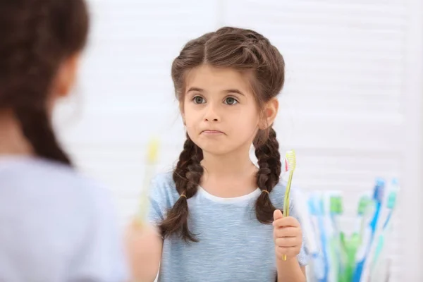 Смешная маленькая девочка чистит зубы — стоковое фото