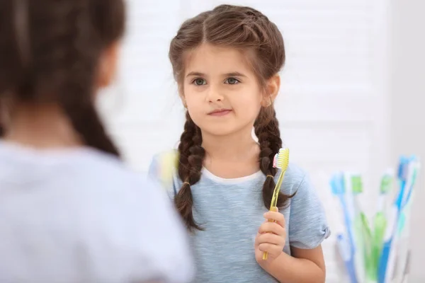Funny little girl brushing teeth