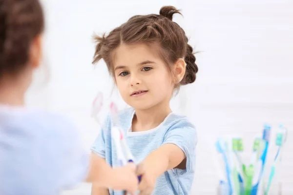 Kleines Mädchen schmiert Zahnpasta — Stockfoto