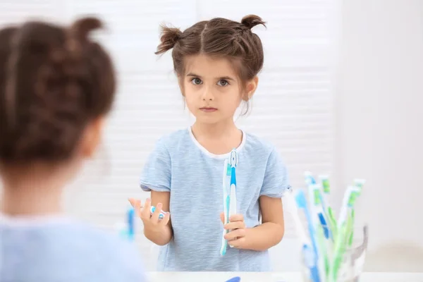 Маленькая девочка играет с зубной пастой — стоковое фото
