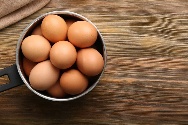 Raw eggs in saucepan — Stock Photo, Image