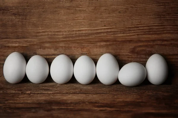 Ovos crus sobre tábua de madeira — Fotografia de Stock