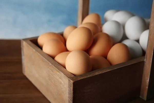 Surowe jaja w drewnianej skrzyni — Zdjęcie stockowe