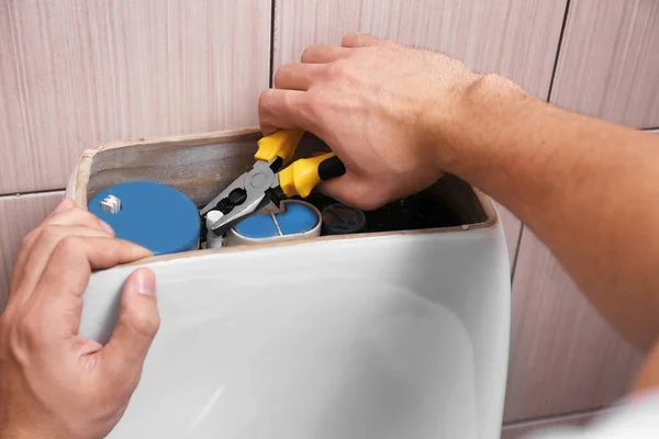 Plumber repairing toilet — Stock Photo, Image