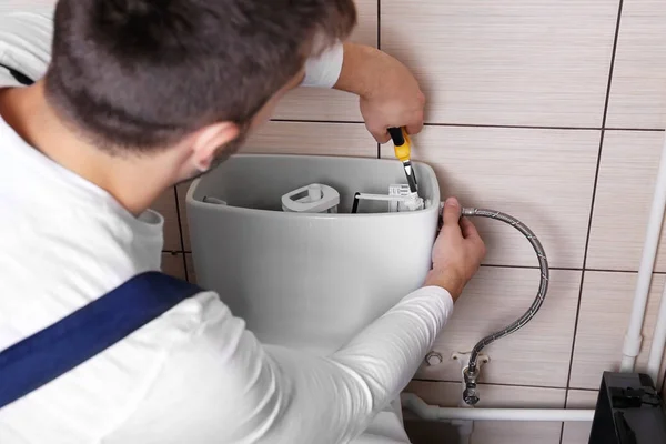 Plumber repairing toilet — Stock Photo, Image