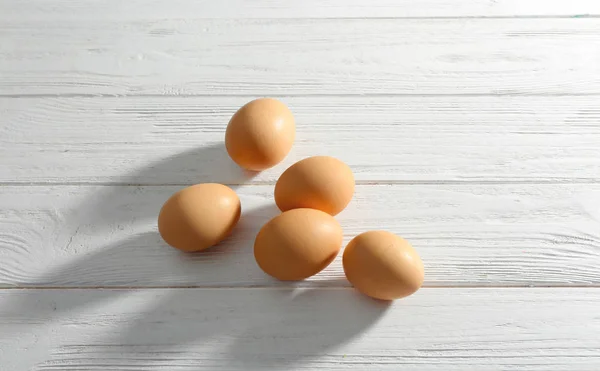 Råa ägg på träbord — Stockfoto