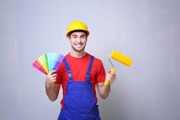 Worker with paint roller and samples — Stock Photo, Image