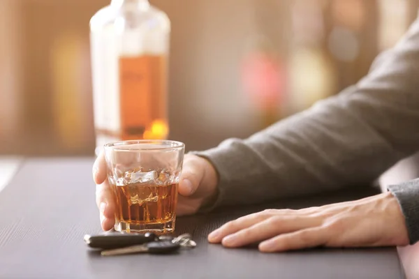 Mann sitzt mit Autoschlüssel und Glas in Bar — Stockfoto