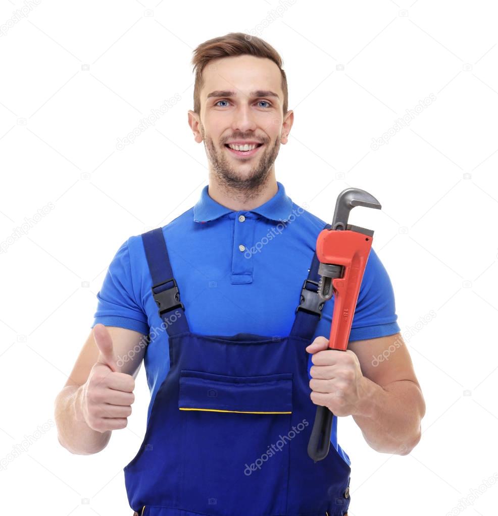 Smiling plumber holding screw-wrench 