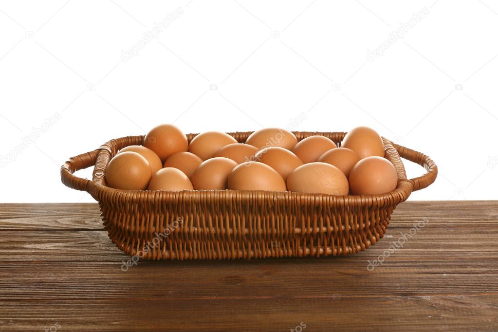 Basket with eggs on wooden table
