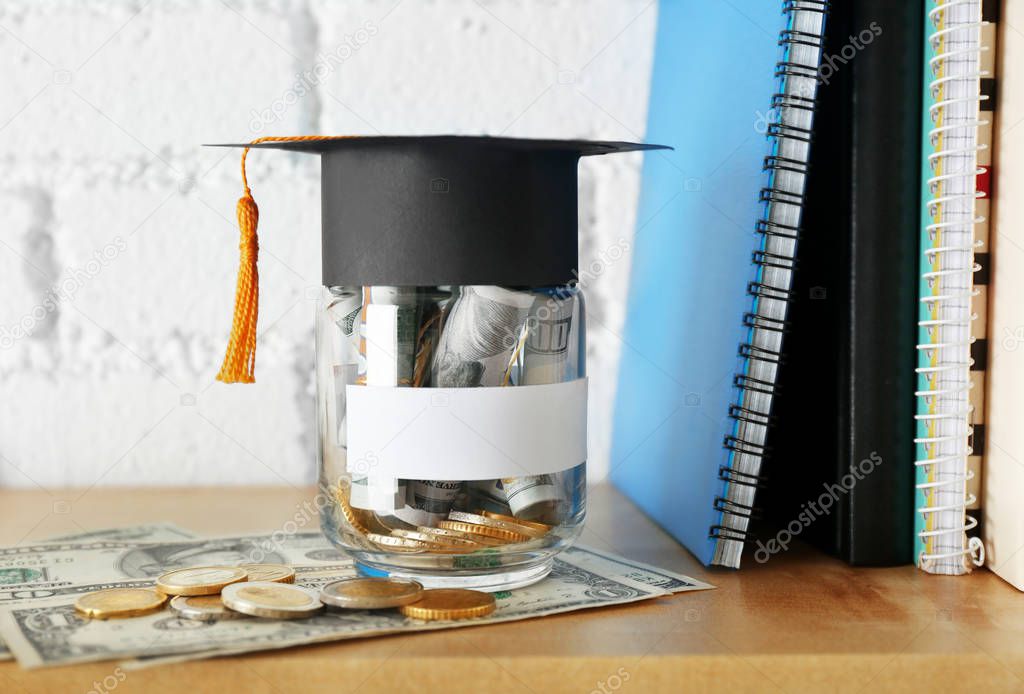 Glass jar with money for education and  books 