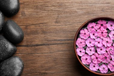 Su ve pembe çiçeklerle kase