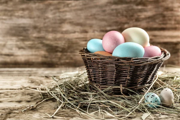 Renkli Paskalya yumurtaları ile hasır sepet — Stok fotoğraf