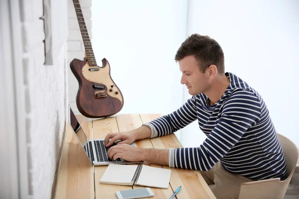 Jeune compositeur assis à son bureau — Photo