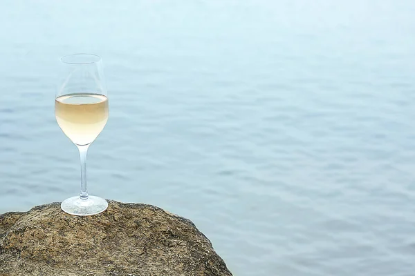 Glas wijn op rots op zee — Stockfoto
