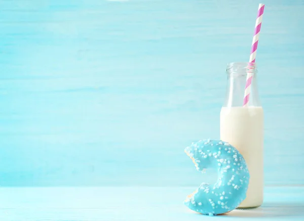 Кусатый пончик и бутылка молока — стоковое фото