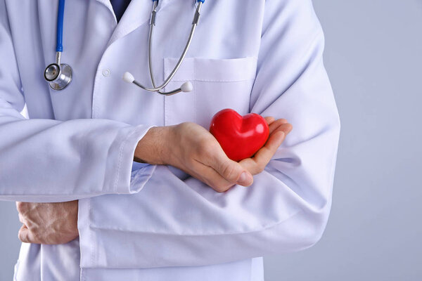 Male doctor holding red heart 