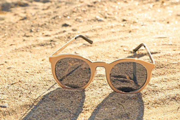 Солнечные очки на песчаном пляже — стоковое фото