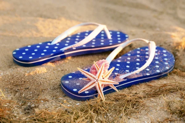 Sandals and starfish on sea sand — Stock Photo, Image