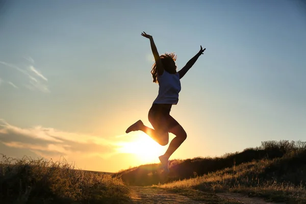 Silhouet Van Vrouw Springen Avondrood Achtergrond — Stockfoto