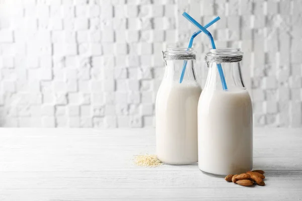 Bottles of sesame and almond milk with straws — Stock Photo, Image