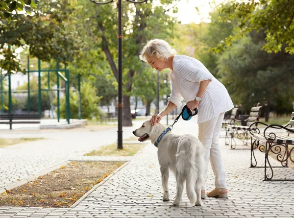 Mulher sênior andando com cão — Fotografia de Stock