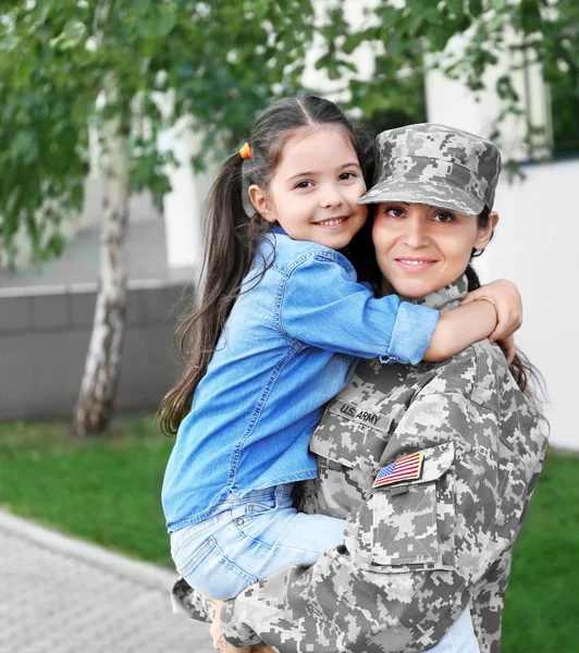 Mother in army uniform and daughter in the street