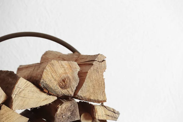 Stack of firewood on light blurred background — Stock Photo, Image