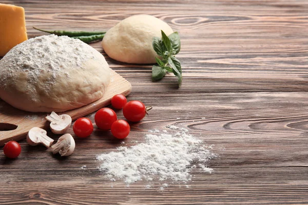 Raw pizza dough with ingredients — Stock Photo, Image