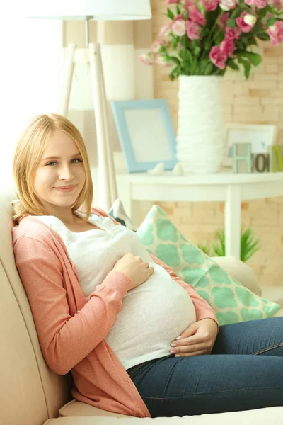 Kobieta w ciąży na kanapie — Zdjęcie stockowe