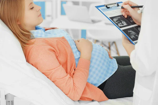 Doctor llenando la historia clínica de la mujer embarazada — Foto de Stock