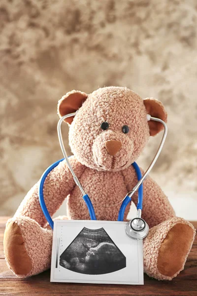 Teddy bear with ultrasound scan of baby — Stock Photo, Image