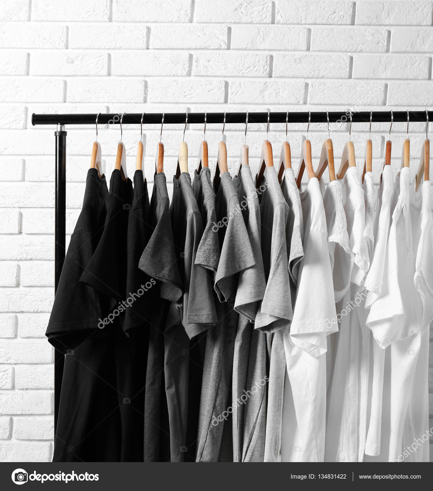 T-shirts on hangers against brick wall Stock Photo by ©belchonock 134831422