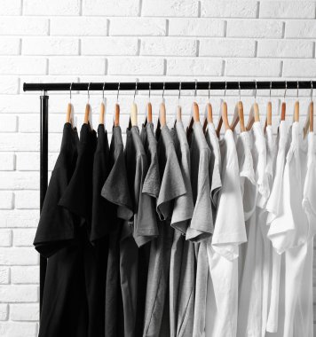 t-shirts on hangers against brick wall clipart